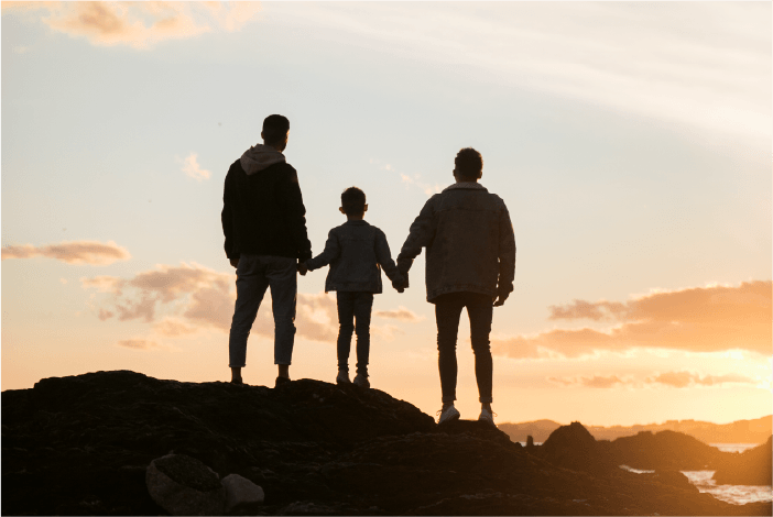 Familia caminando junto al mar al atardecer
